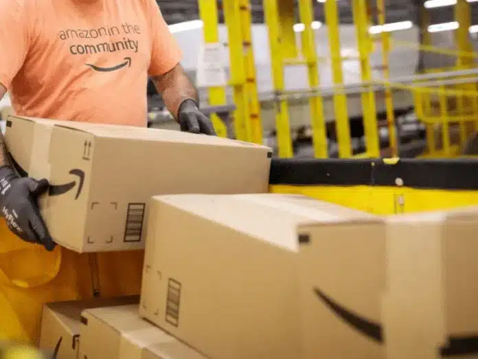 Amazon worker moving boxes inside a fulfilment center during FBA packaging and handling.