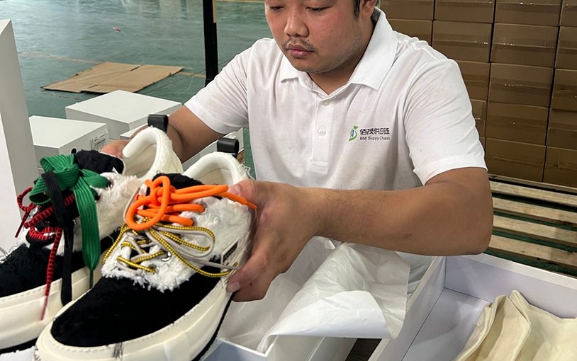 Warehouse staff inspecting and packaging footwear products as part of China fulfillment and Amazon FBA prep services