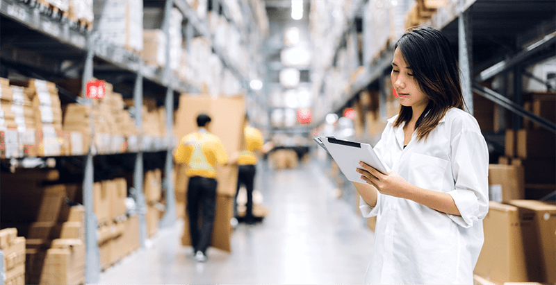 Female warehouse staff conducting an inventory audit using a tablet, showcasing real-time digital tracking in modern B2B fulfillment.
