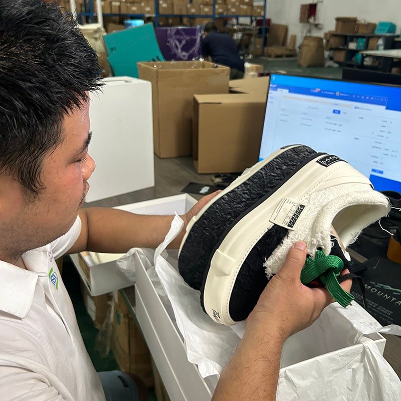 Worker inspecting product quality and organizing goods in warehouse storage during the B2B fulfillment process.