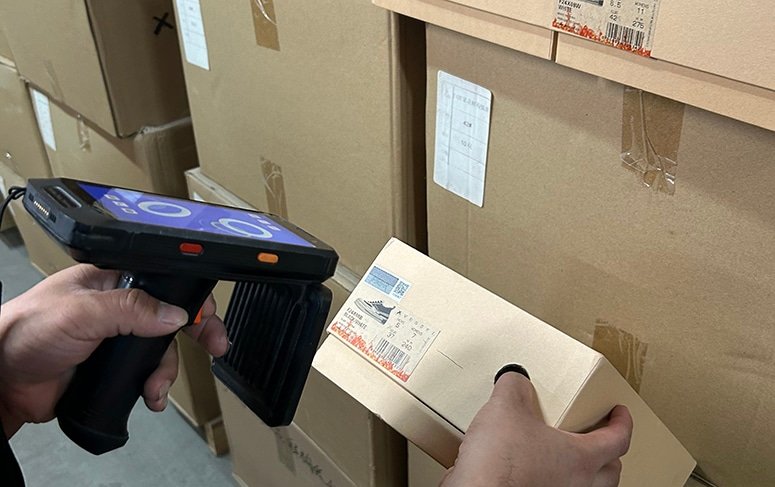 Warehouse staff using a handheld barcode scanner to verify SKU labels during the pick and pack process at BM Supply Chain’s fulfillment center.