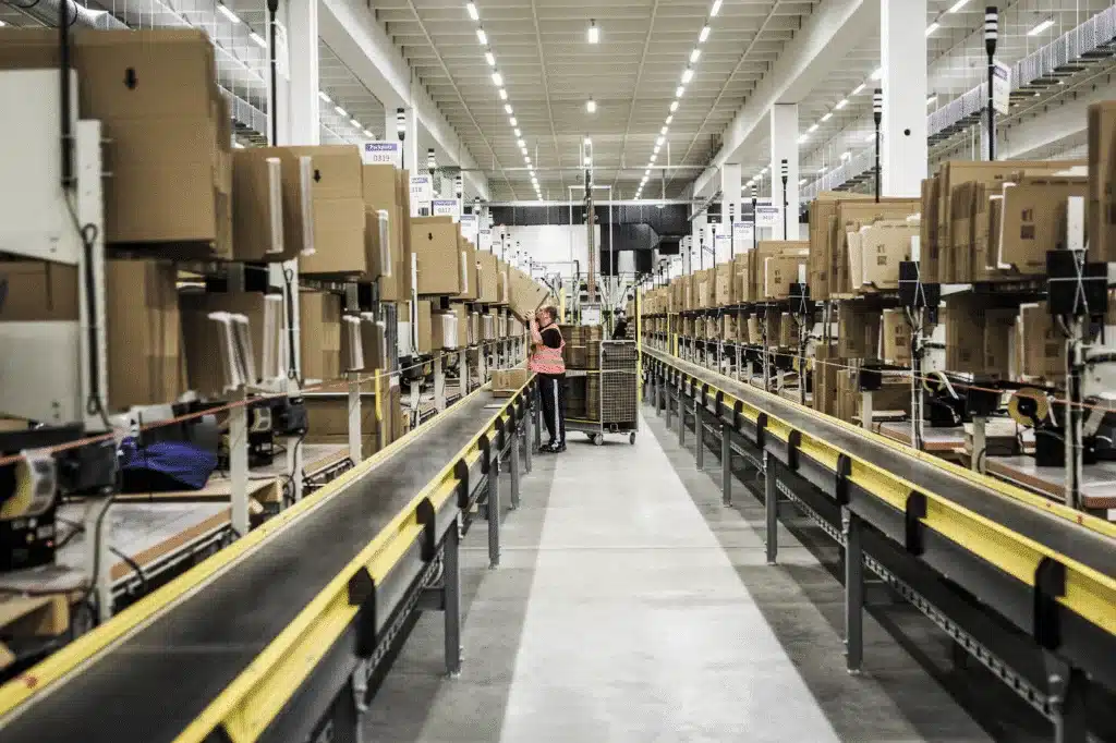 Inspector checking cartons on an Amazon conveyor line during pre-shipment inspection.