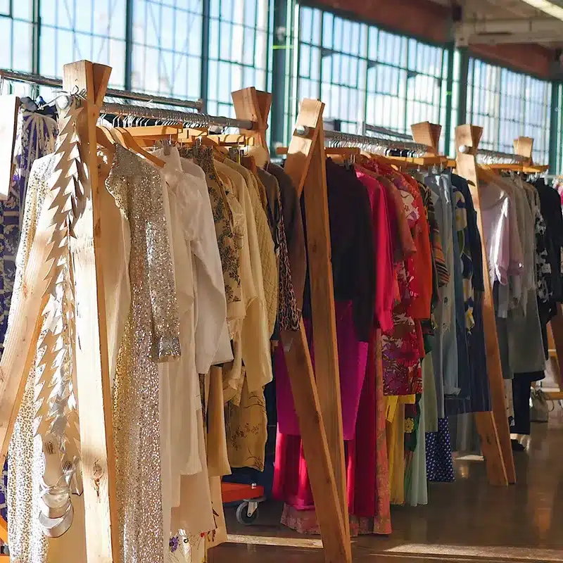 Clothing racks with assorted garments in a fulfillment warehouse for apparel storage and processing