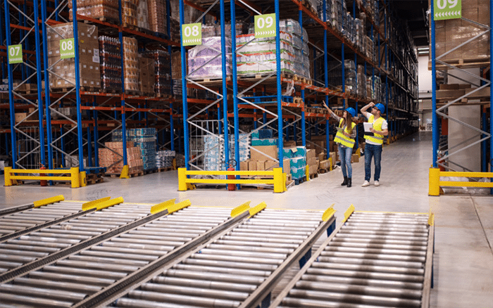 Large China fulfillment warehouse with racks of palletized goods and staff inspecting inventory as part of B2B logistics operations