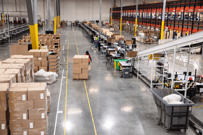 Wide view of a large China fulfillment warehouse with conveyor lines, pallets, and staff working on B2B order processing