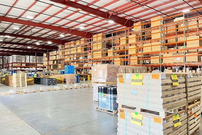Large warehouse storage area with pallets, cartons, and shelving used for B2B fulfillment and bulk inventory management