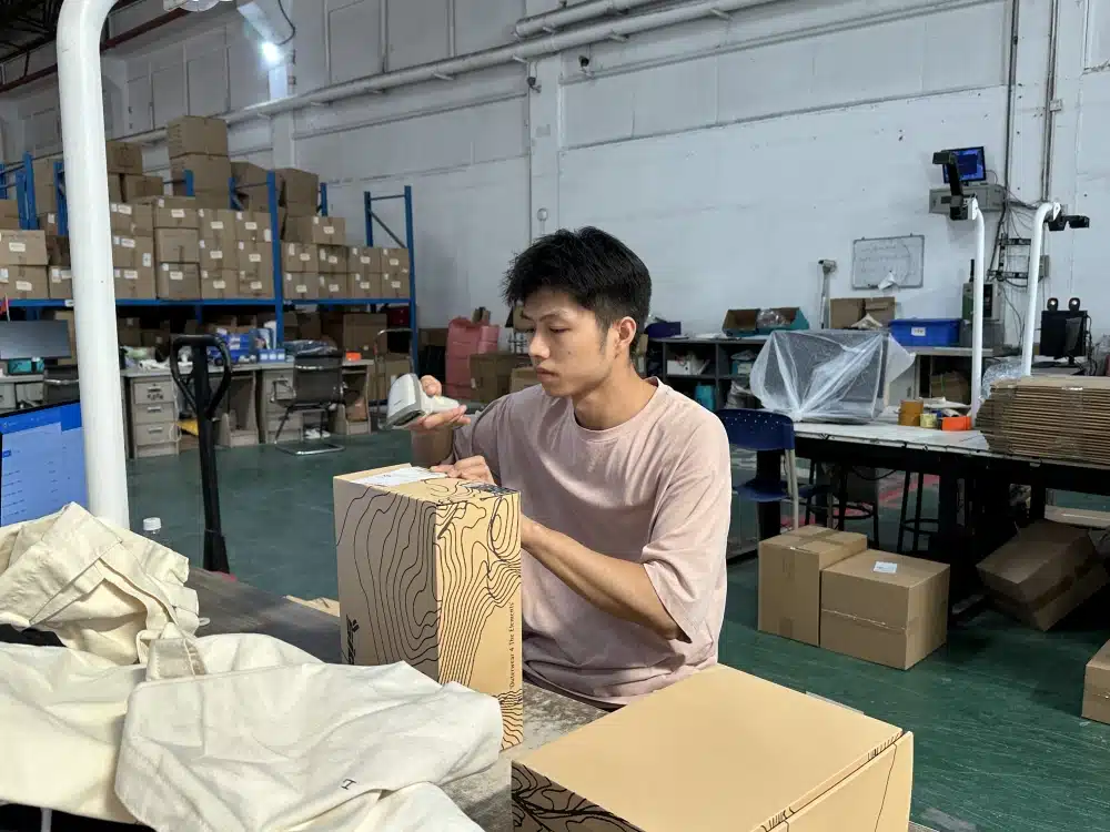 Warehouse employee scanning a shipping label during ecommerce fulfillment for products shipped from China to USA