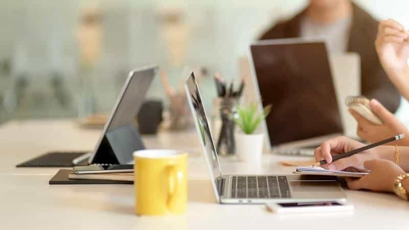 Crowdfunding team reviewing shipping costs, fulfillment expenses and hidden fees in a budget spreadsheet for their Kickstarter campaign