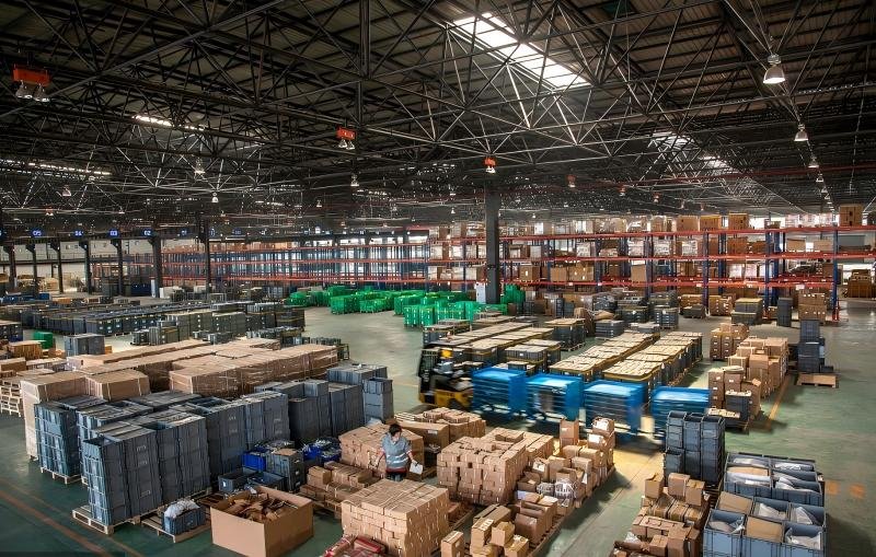 Modern fulfillment warehouse with automated storage and staging areas for crowdfunding campaigns including late pledges