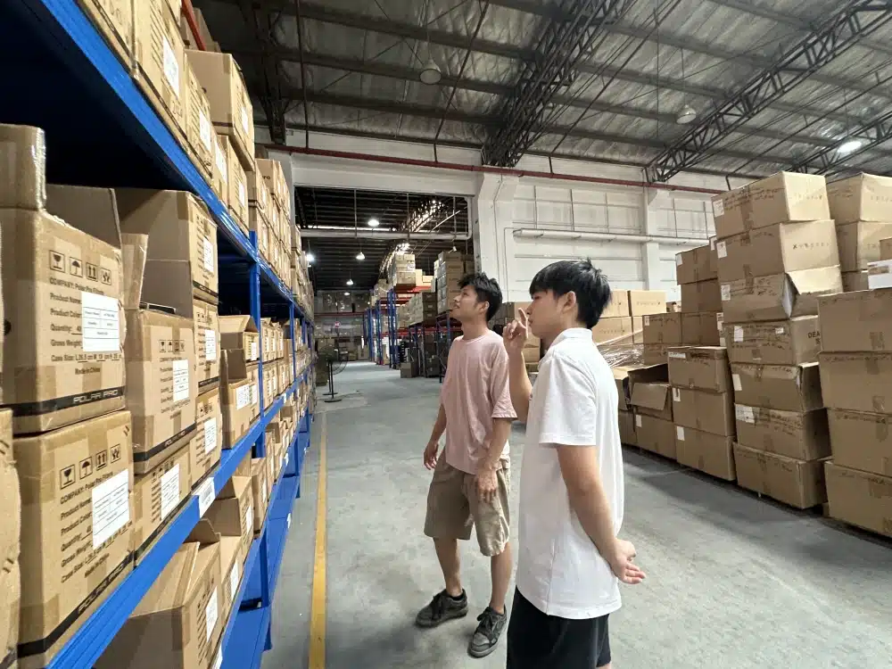 Warehouse worker checking boxed inventory with a clipboard as part of Prime Day stock readiness checks