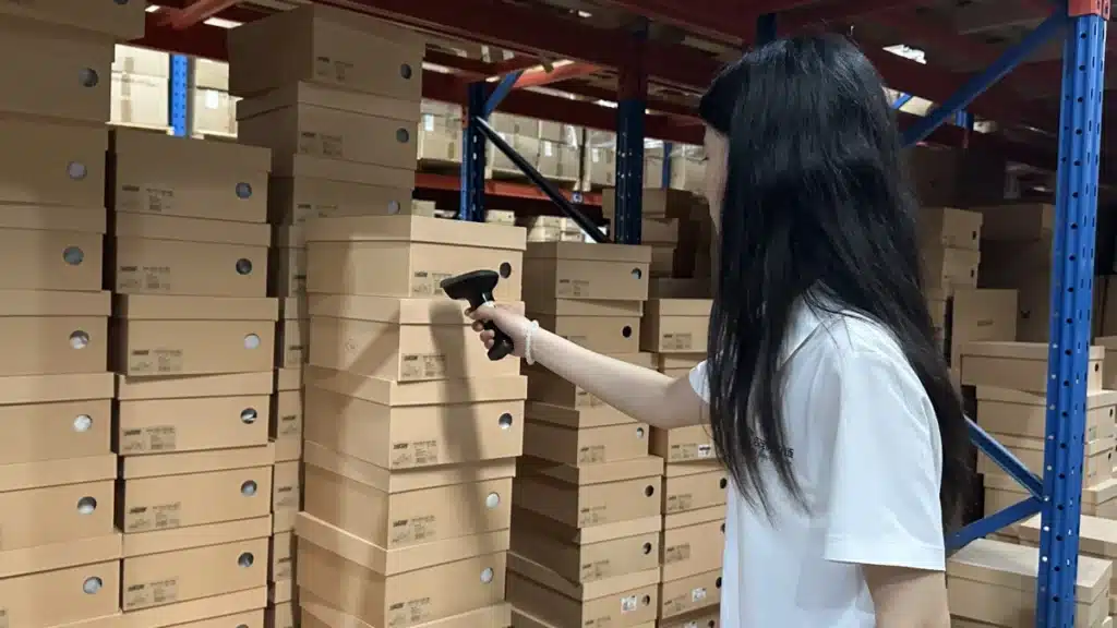 Warehouse worker scanning product boxes for real-time inventory tracking during bulk ecommerce fulfillment with a 3PL partner.