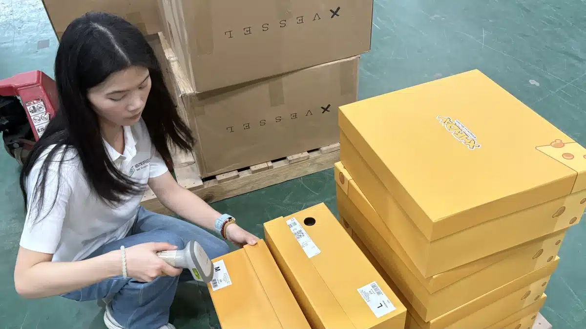 Warehouse worker scanning individual product labels during DTC order fulfillment, supporting SKU accuracy, real-time inventory control, and multi-channel fulfillment operations.