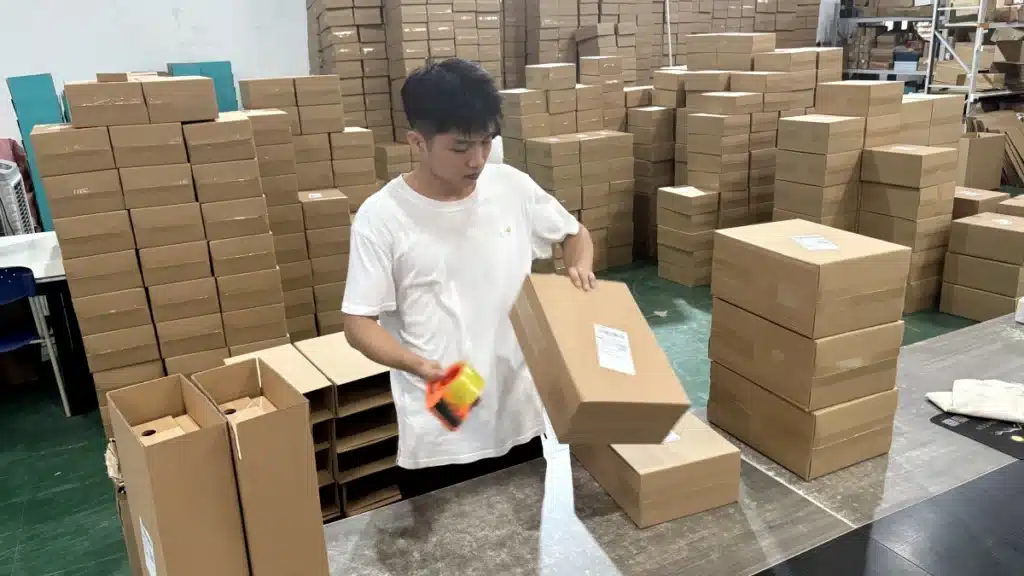 Warehouse worker packing individual ecommerce orders as part of an omnichannel fulfillment operation supporting online DTC, retail, and wholesale distribution.