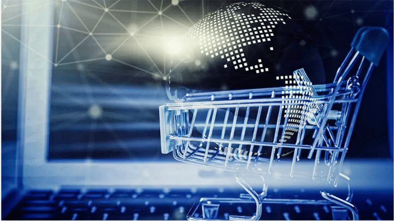 Digital shopping cart overlaying a glowing globe on a laptop screen, symbolizing global e-commerce strategies to boost sales velocity and avoid long-term storage penalties.