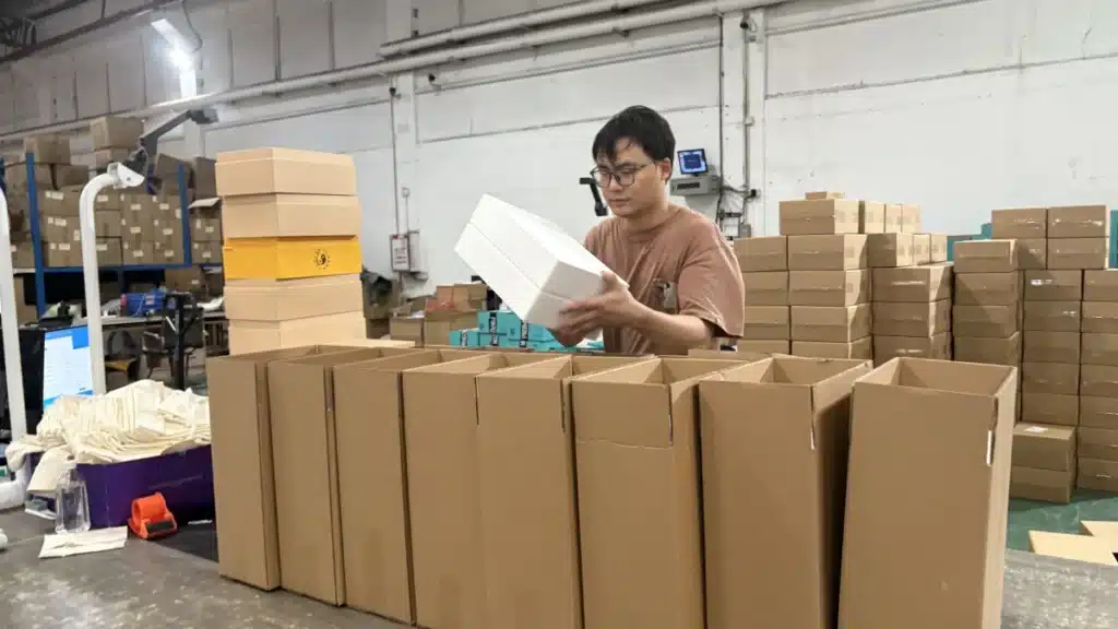 Warehouse worker sorting and inspecting products during a 3PL product recall, supporting defective inventory classification, rework, and reverse logistics management.