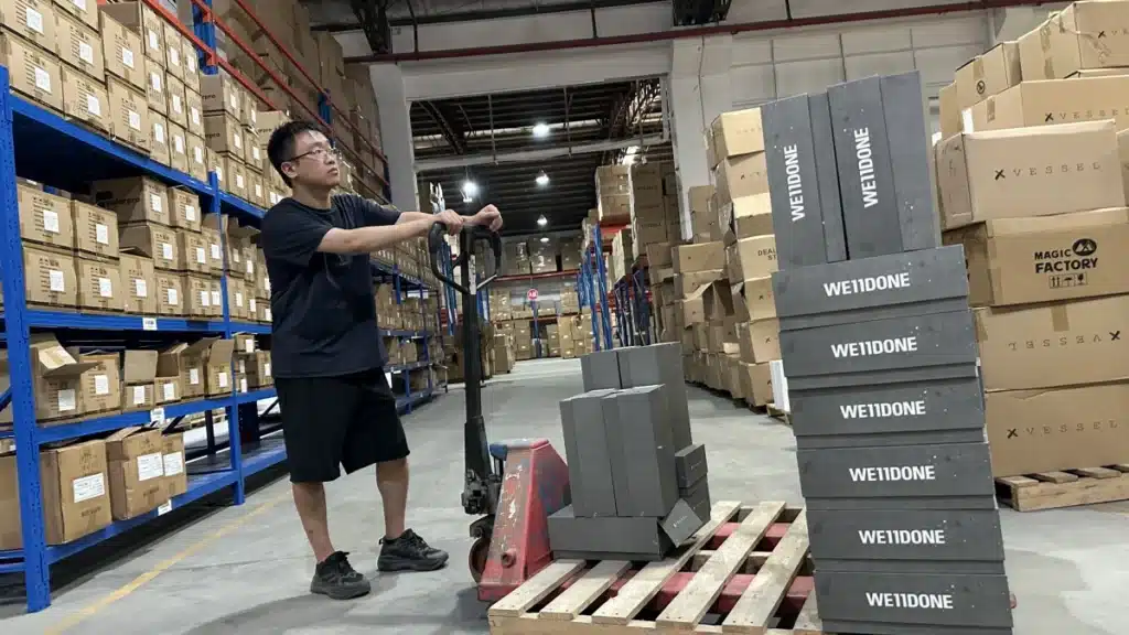 3PL warehouse worker moving ecommerce products with a pallet jack as part of an organized picking and inventory handling workflow.