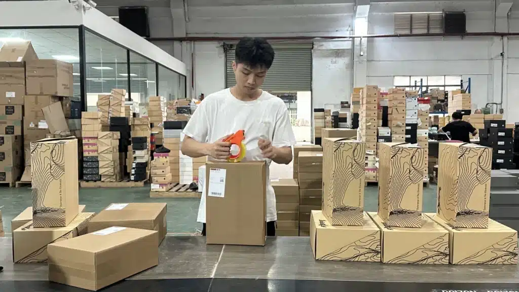 Warehouse worker packing and labeling an ecommerce order for shipment using fulfillment data to balance shipping cost, delivery speed, and customer expectations.