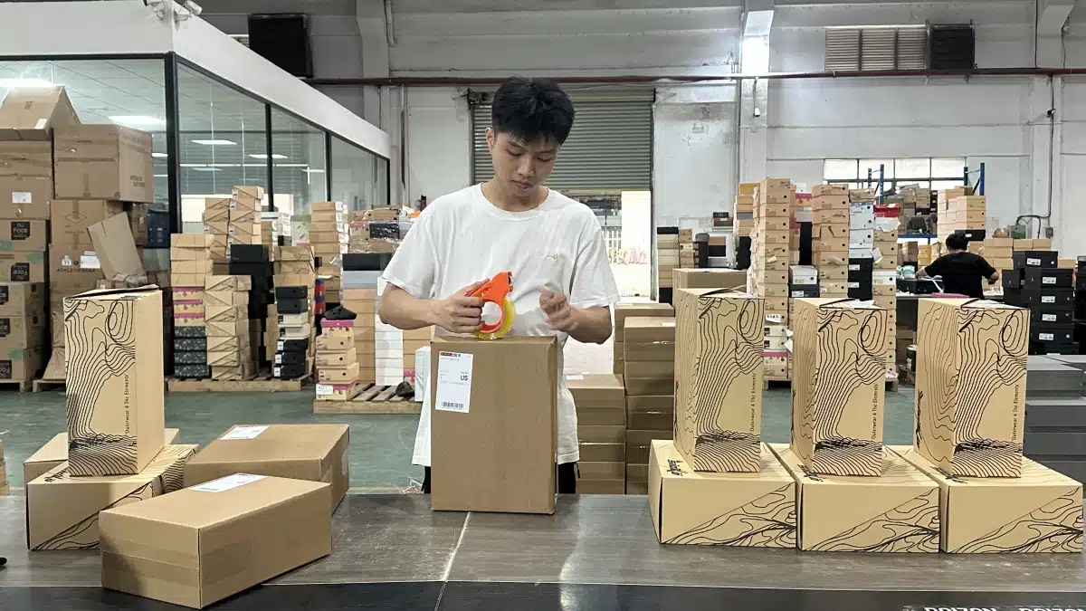 Warehouse worker packing and labeling an ecommerce order for shipment using fulfillment data to balance shipping cost, delivery speed, and customer expectations.