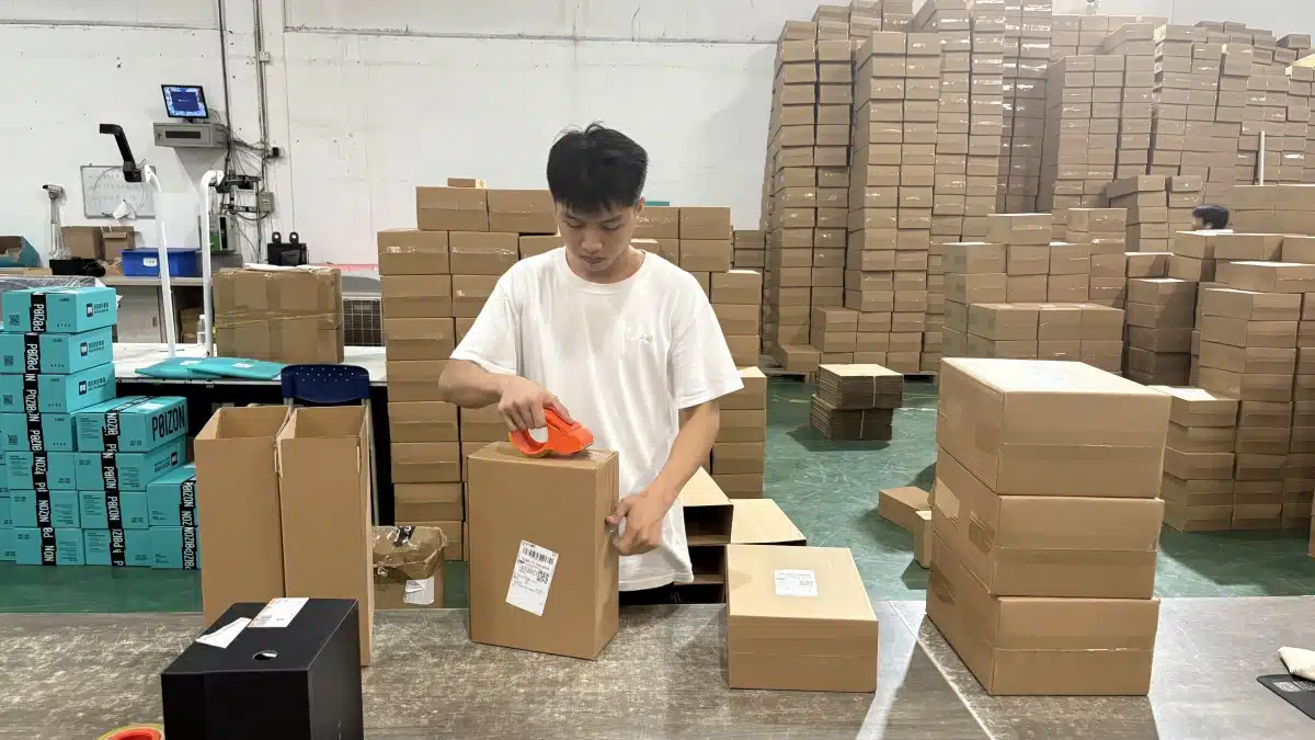 Fulfillment worker sealing a customer order in a warehouse as part of an efficient pick and pack process for growing small businesses.