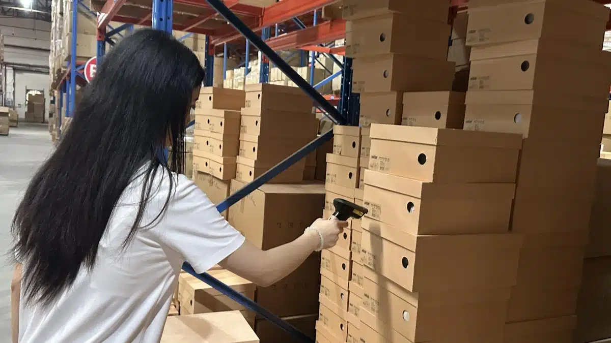 Warehouse worker scanning stored products for SKU-level inventory tracking, supporting 3PL risk management, data continuity, and emergency warehouse transition planning.