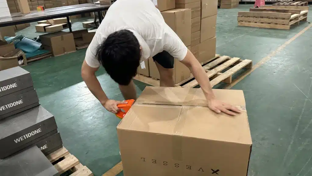 Warehouse employee sealing a shipping carton during eCommerce order fulfillment to support reliable delivery speed and optimized shipping options at checkout.
