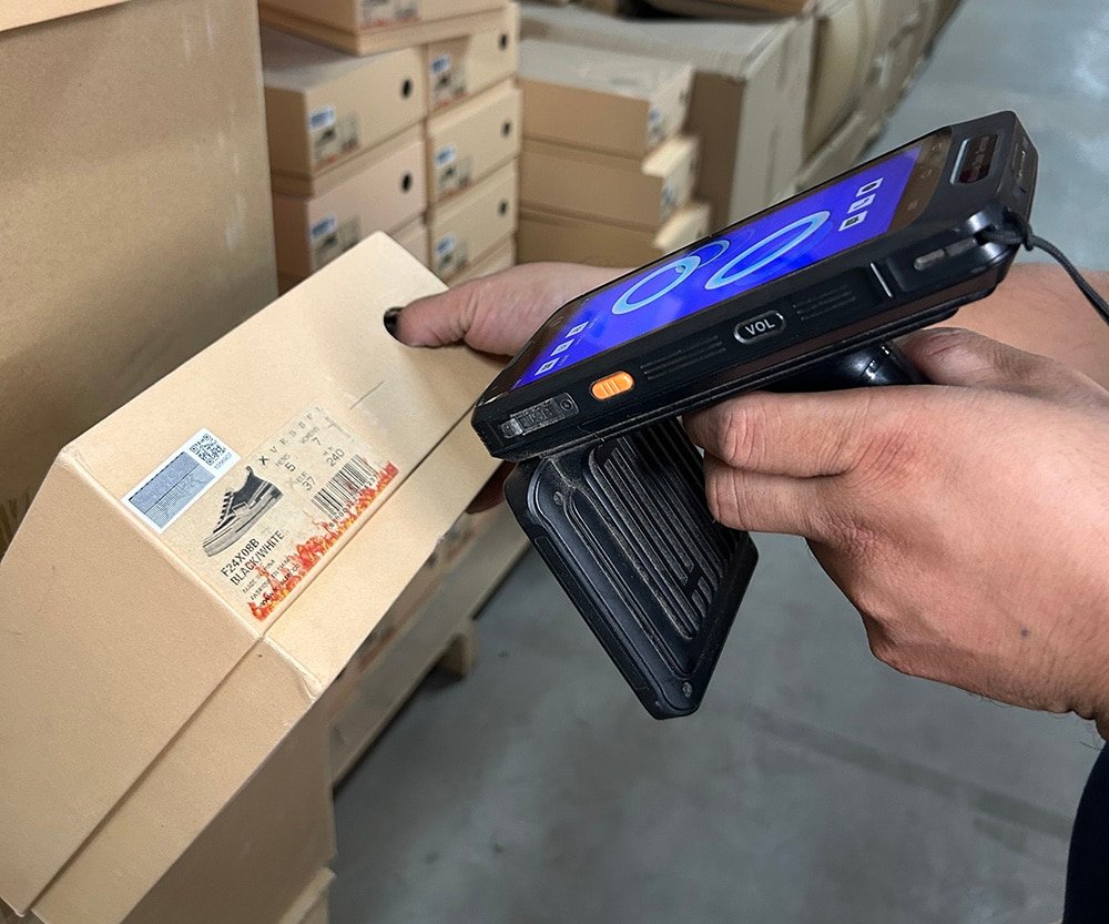 warehouse worker scanning barcode on package during pick and pack fulfillment process