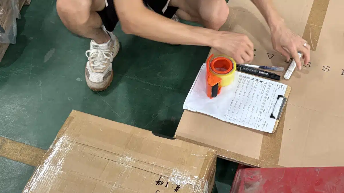 3PL warehouse worker inspecting recalled inventory and recording product details for defective inventory identification, traceability, and recall management.