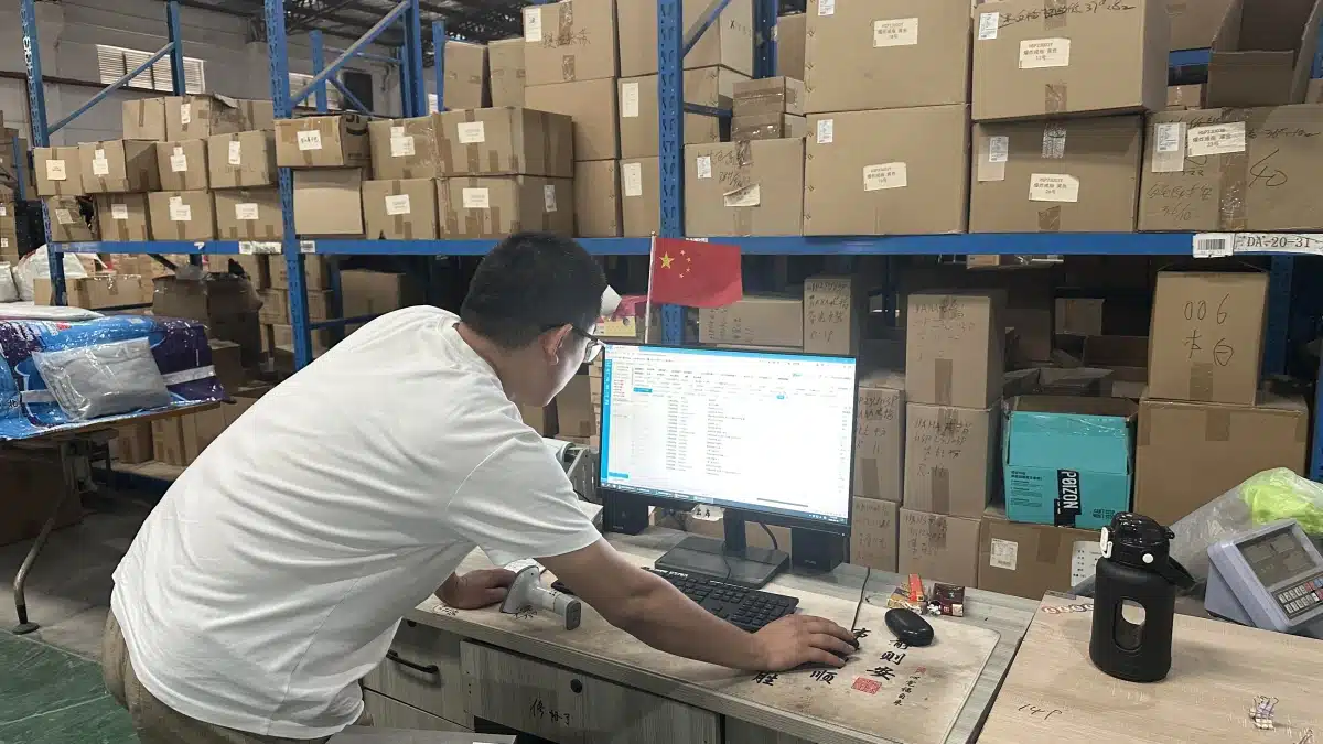 Warehouse employee managing ecommerce orders through a fulfillment system to analyze shipping costs, order value, and shipping cost as a percentage of AOV.