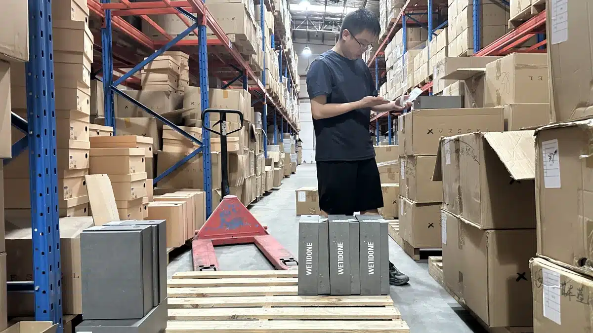 Warehouse employee checking picked shoe products against an order list in a 3PL warehouse to improve picking accuracy and fulfillment precision.