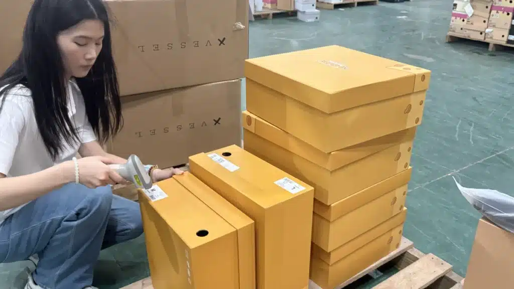 Warehouse employee scanning product labels during pick and pack fulfillment to verify orders and improve inventory accuracy in a 3PL warehouse.