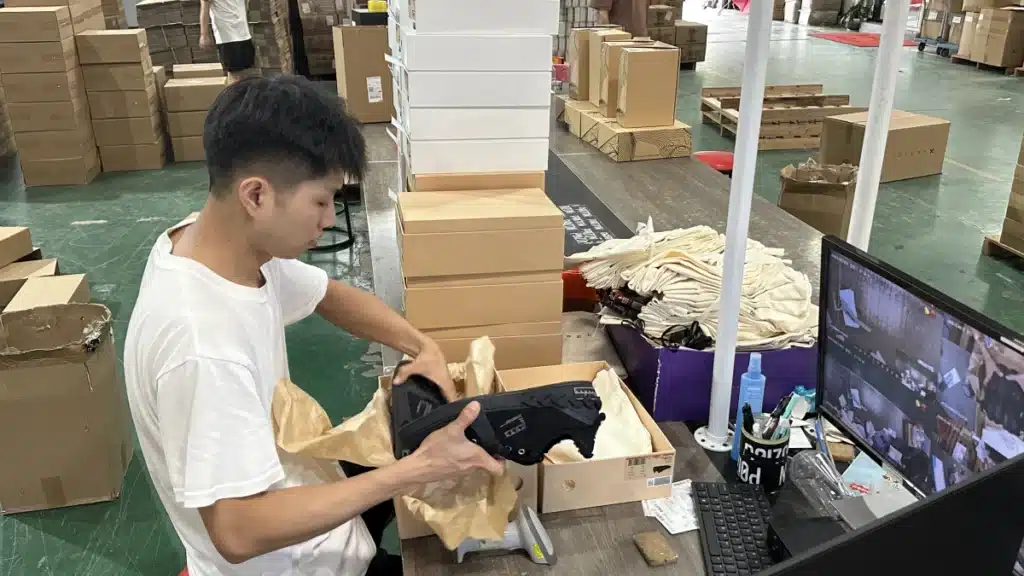 Warehouse worker packing a customer order at a fulfillment station, demonstrating outsourced pick and pack services for eCommerce businesses.