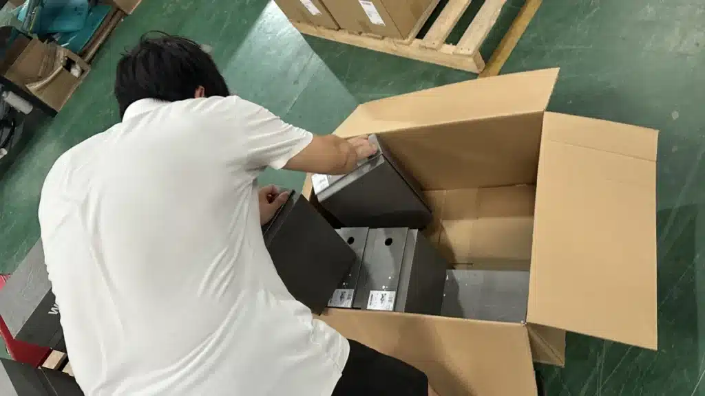 Fulfillment worker packing multiple product boxes into a shipping carton as part of an outsourced pick and pack order fulfillment process.