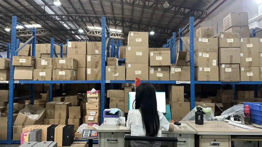 Warehouse employee managing orders and inventory at a workstation inside a professional warehousing and fulfillment facility.