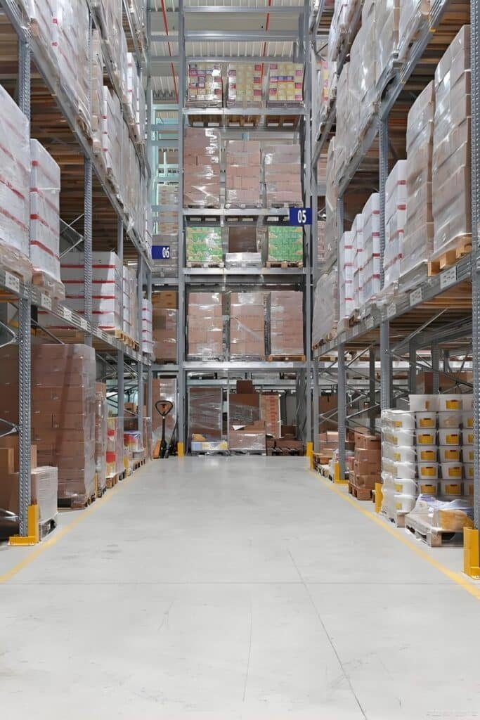 High-density pallet racking in a logistics center aisle, illustrating the importance of storage duration management and space utilization to avoid hidden costs in pick and pack services.
