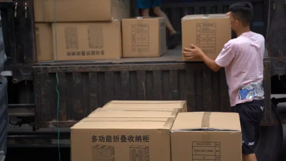 Warehouse worker loading packaged products as part of 3PL fulfillment operations, inventory handling, and shipping preparation for eCommerce orders