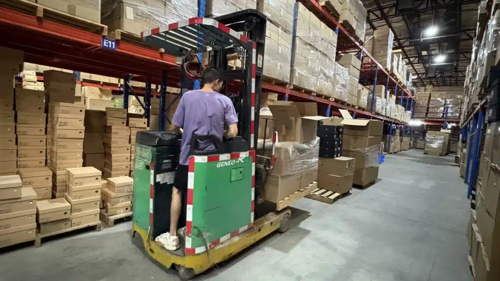 3PL warehouse worker operating a forklift among stored inventory to support scalable ecommerce fulfillment and special handling requirements.