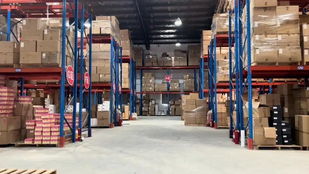 Organized fulfillment warehouse with inventory racks showing the difference between 3PL logistics services and basic warehousing for eCommerce businesses