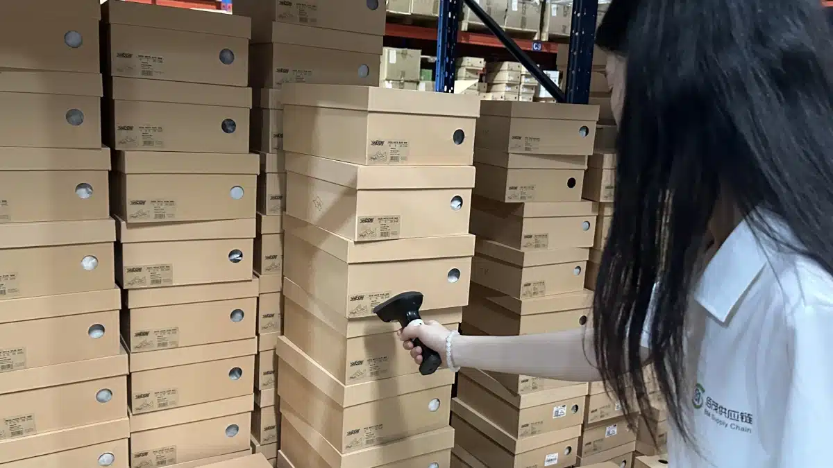 Warehouse worker scanning product labels to track inventory accurately, demonstrating barcode-based inventory management and real-time stock control in warehousing services.