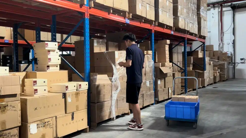 Warehouse worker picking products from inventory for China pick and pack fulfillment and international order processing