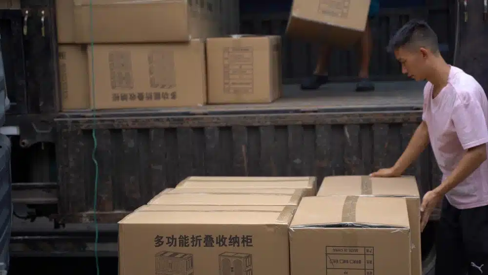 Warehouse worker loading packaged orders for eCommerce fulfillment and cross-border shipping during logistics operations