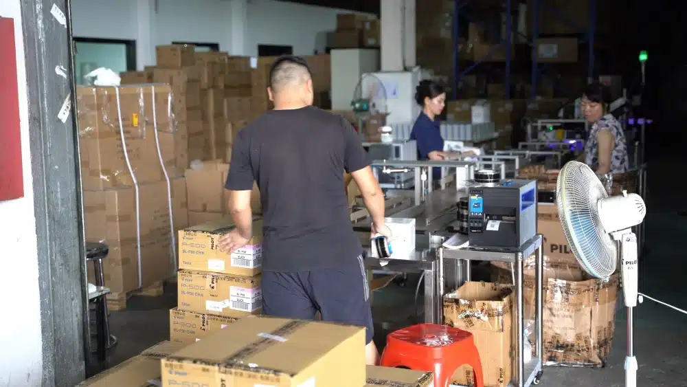 Warehouse team processing packaged orders as part of eCommerce fulfillment, including picking, packing, labeling, and shipping preparation