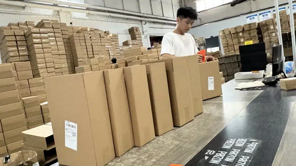Warehouse worker packing and preparing labeled cartons for shipment, demonstrating the packing and order fulfillment process included in professional warehousing services.