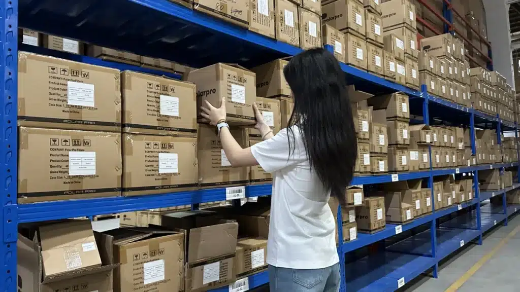 Warehouse worker selecting labeled cartons from storage racks during the pick and pack process, demonstrating accurate order picking in logistics fulfillment.