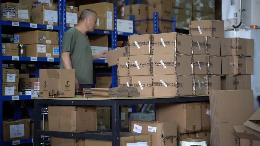 Warehouse worker preparing packed eCommerce orders as part of pick and pack fulfillment and shipping cost optimization