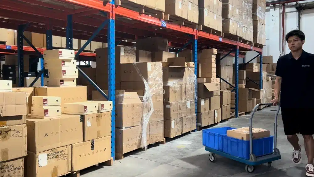 Warehouse worker moving picked eCommerce orders for fulfillment and real-time shipment tracking