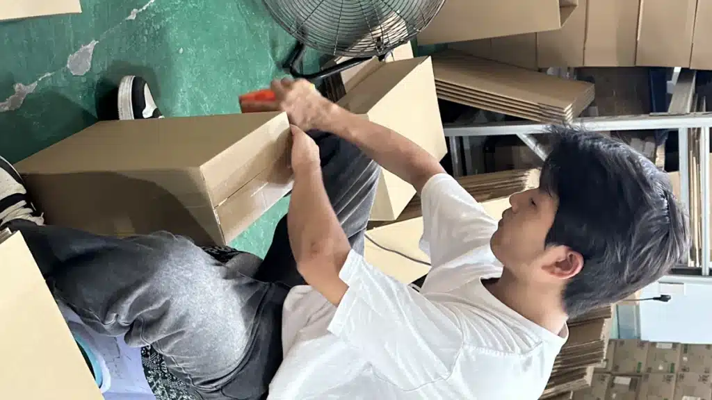 Warehouse worker packing a customer order into a carton, demonstrating pick and pack fulfillment services provided by a warehousing company in China.