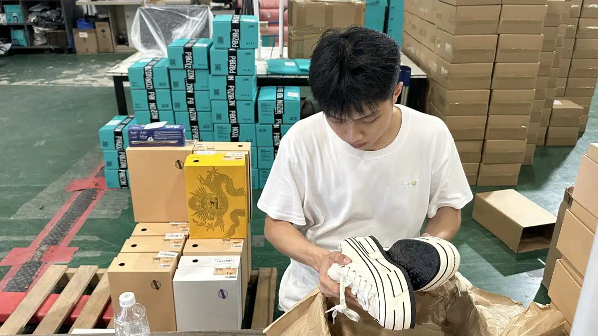 Warehouse worker inspecting and preparing products for shipment, showing picking, packing, and quality control functions within logistics warehouse operations.