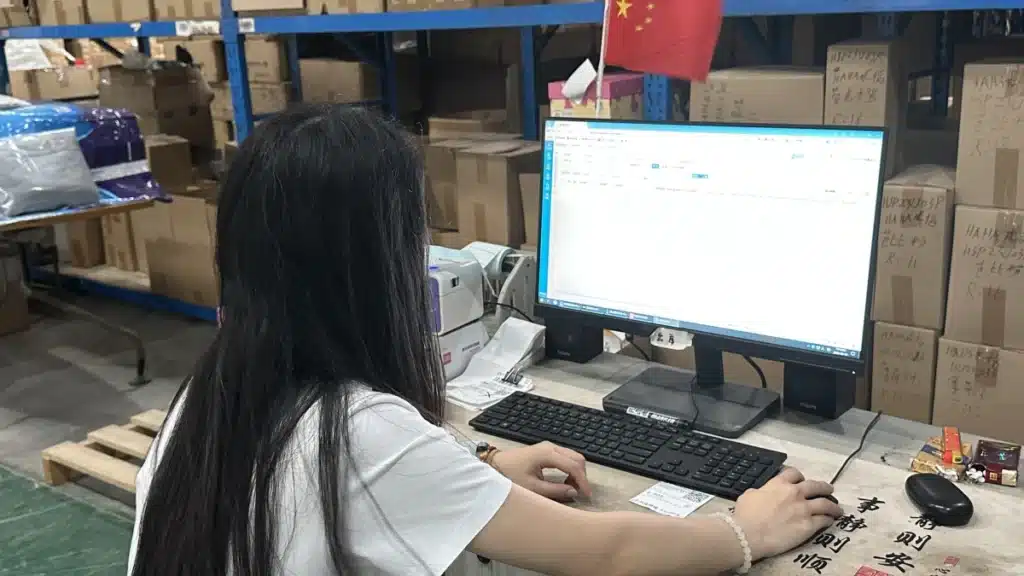Warehouse staff using a warehouse management system to manage inventory and orders, highlighting WMS technology and real-time inventory tracking in a China warehouse.