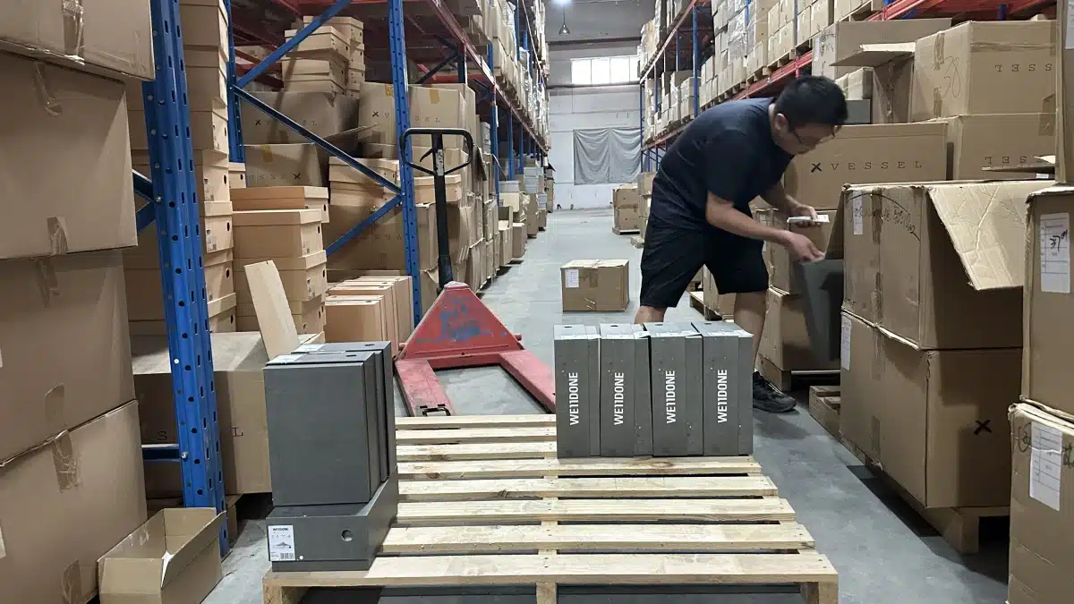Warehouse worker preparing products for fulfillment in a China warehouse, showing operational efficiency, inventory handling, and order processing capability.