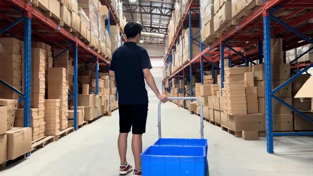 Warehouse worker packing customer orders in an eCommerce fulfillment center providing pick, pack, labeling, and shipping preparation